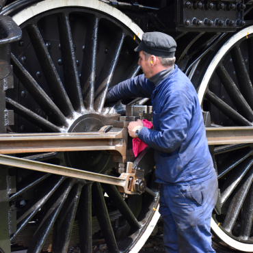 Dieser Mann erscheint klein vor dem Rad der Dampflokomotive - Leserfoto: Hansjürg Oesch /  18/ 2025