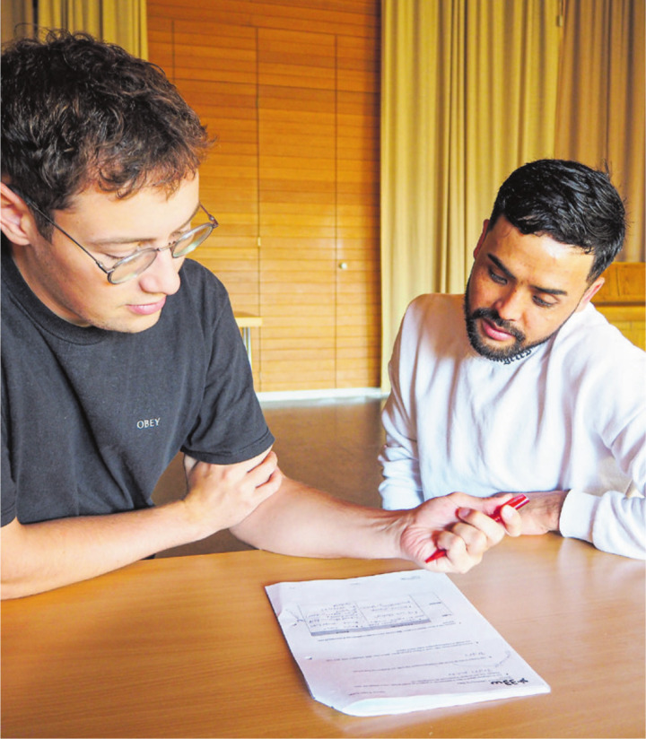 Mentor Philipp Gross und der Lernende Javid Muradi arbeiten an Hausaufgaben.