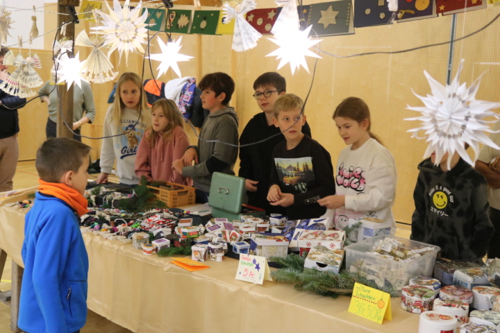 Kinder der Mittelstufenklassen hinter adventlich dekorierten Marktständen. Fotos: Markus Bösch